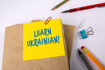 Learn Ukrainian. Textbooks and stationery on a white table