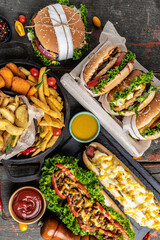 Close-up of home made tasty burger and hot dogs with fried chicken french fries. raditional American food. fast food. vertical image. top view