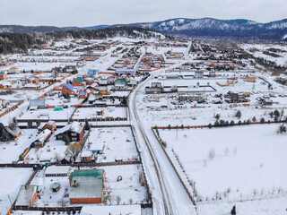 March in the village of Mansky, the snow began to melt, wooden cottages, photo from quadcopter