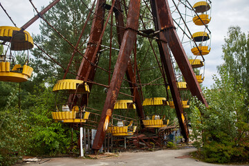 Fototapeta na wymiar Old abandoned Ferris wheel in the amusement park in the ghost town Pripyat Ukraine. Chernobyl nuclear power plant zone of alienation