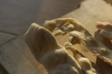 Fototapeta na wymiar Homemade bread sticks in the morning sun on wooden background. Close up, macro photo of structure. Selective focus.