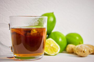 cup with tea , ginger and lime on a white background