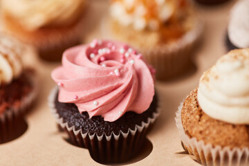 Lots of colorful cupcakes with raspberry and other creams