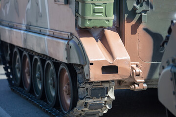 Military tank, asphalt street. War weapon, armored vehicle camouflage color, close up view