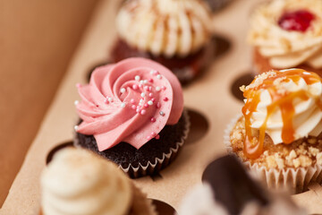Brown cupcake with pink raspberry cream as a topping