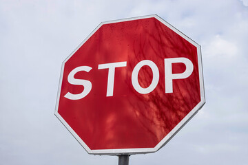 roadside red stop sign on a cloudy background. Sign isolated
