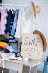 Swap party. Event for the exchange. Casual clothes on hangers, shoes, hats, bags Reduce and reuse...