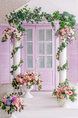 porch of the house is in flowers . Photo zone with a lilac door