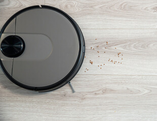 Robot vacuum cleaner is cleaning floor, close on dust