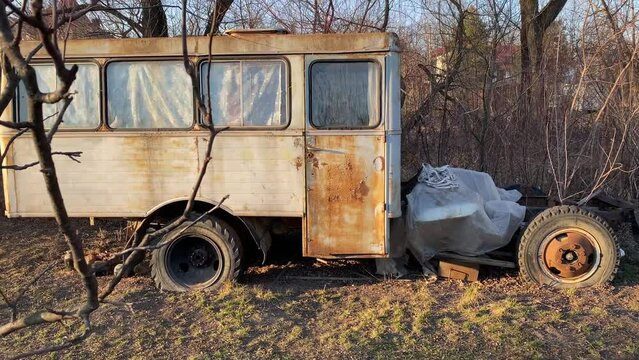 Old abandoned van in contryside Ukraine. Rusty vintage car camper without engine at sunset