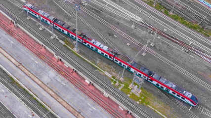 Aerial view on a train passing on the tracks of an Italian railway.