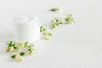 Fototapeta na wymiar White organic cosmetic product with white flowers