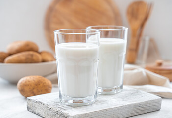 Vegetarian potato milk in two glasses on a light background close-up. Vegetable milk.