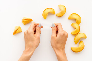 Female hands open Chinese fortune cookie. Chinese New Year background