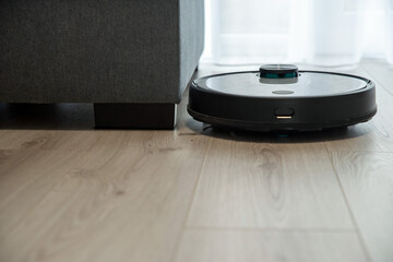 Robot vacuum cleaner is cleaning floor, top view - Powered by Adobe