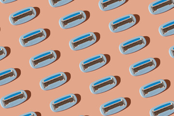 Replacement razor blade cassettes pattern on a pastel pink background.