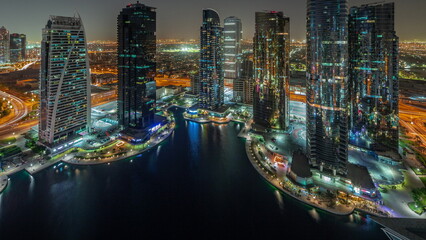 Tall residential buildings at JLT aerial all night timelapse, part of the Dubai multi commodities centre mixed-use district.