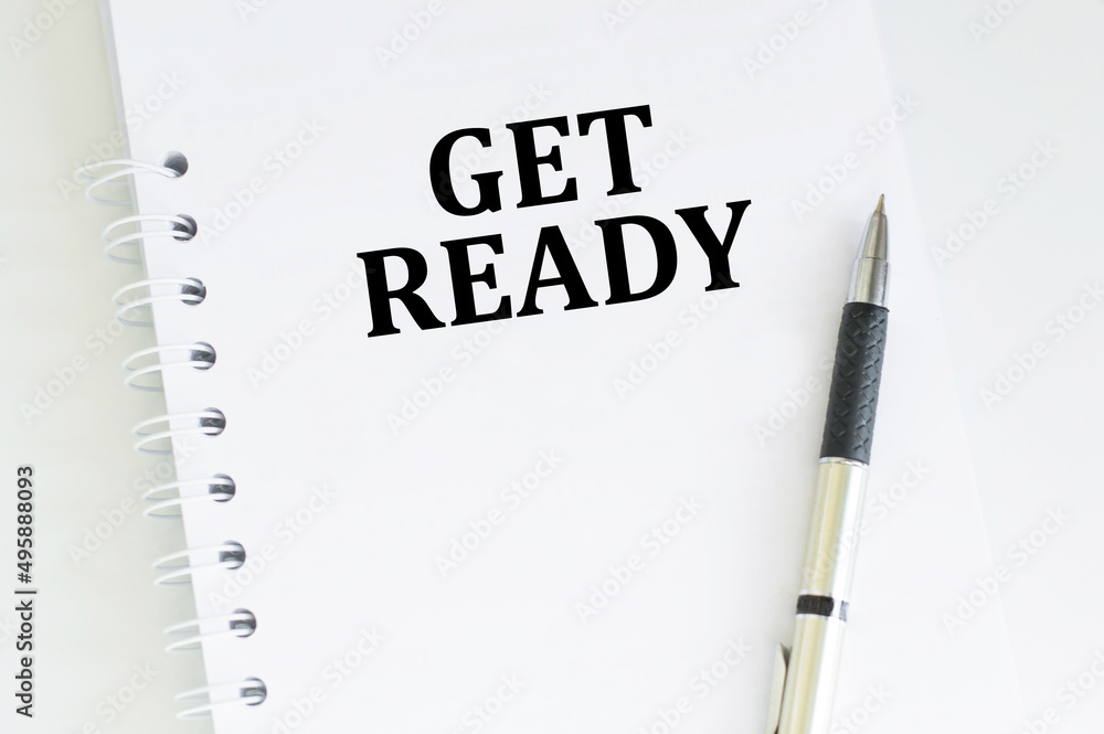 Aufkleber notebook with get ready word on white table. business conceptual