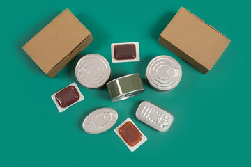 Fototapeta na wymiar Canned food set, terrines cardboard boxes on green background. Horizontal photography made in studio.