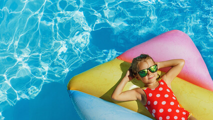 Child in swimming pool. Having fun on vacation at the hotel pool. Colorful vacation concept. - obrazy, fototapety, plakaty