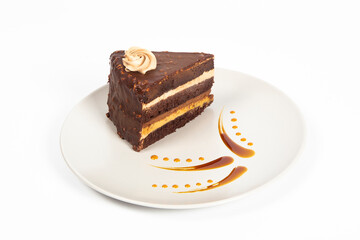 chocolate cake on plate with caramel sauce, white background