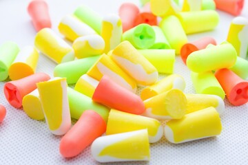 Pile of earplugs against noise in different colors isolated on white background.Protective...