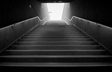 Fototapeta na wymiar Dark underground stairs leading up into the light.