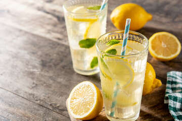 Glass of fresh lemonade on wooden table. Copy space
