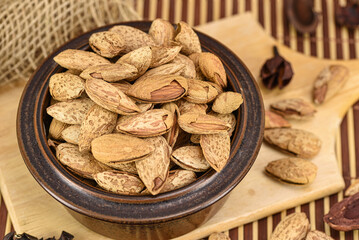 Almonds on wooden board in ceramic bowl 