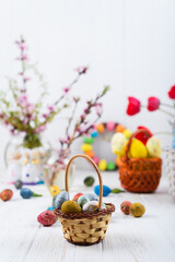 Obraz na płótnie Canvas easter colorful eggs with tulips and spring flowers on a white wooden background