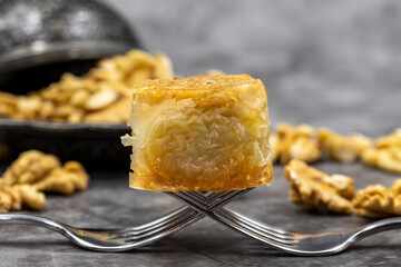 Walnut baklava on a dark background. Traditional Turkish cuisine delicacies. Local name is cevizli saray sarma baklava