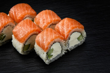 Philadelphia roll sushi with tuna, cucumber and cream cheese on black background for menu. Japanese food