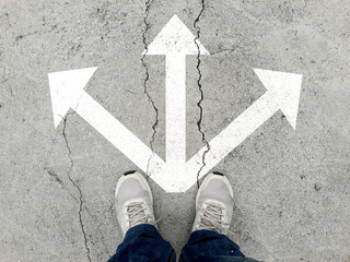 Shoes and arrows pointing in different directions on the road 