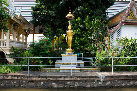 Ancient buddha Leela attitude statue or antique pang lila figure image  for thai people foreign travelers travel visit and respect praying riverside canal at Wat Tanot temple in Nonthaburi, Thailand