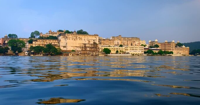 Udaipur City Palace view from lake Pichola. Luxury white palace as an example of Rajput architecture of Mewar dynasty rulers of Rajasthan is famous tourist Indian landmark. Incredible India heritage.