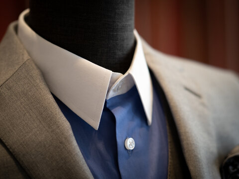 Close up of jacket . Light Grey wool jacket with blue shirt white collar on mannequin