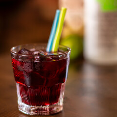 cherry alcohol drink with color straws on wooden table square