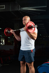 Male athlete lifts the barbell