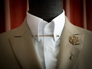 Lapel pin on beige jacket with white shirt