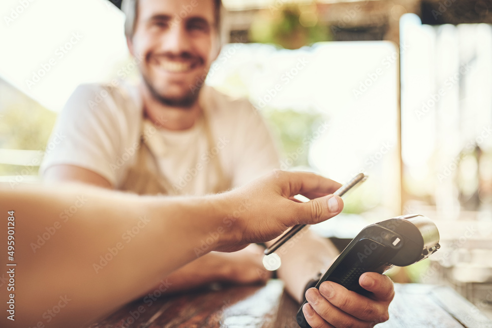 Poster pay the smart way. cropped shot of a customer making a wireless payment in a coffee shop.