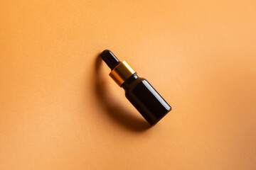 jar of facial cosmetic oil on beige background