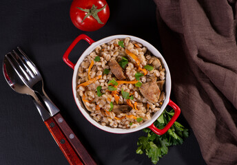 Easy bulgur pilaf (pilavi) with tomatoes in a ceramic bowl on a dark background close-up.