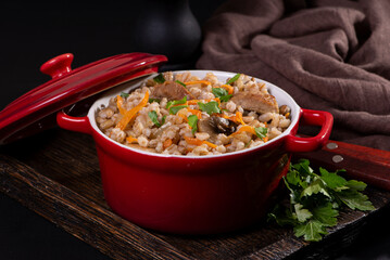 Easy bulgur pilaf (pilavi) with tomatoes in a ceramic bowl on a dark background close-up.