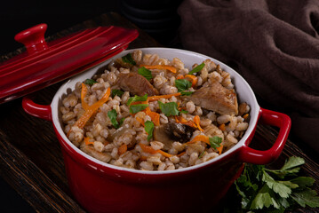 Easy bulgur pilaf (pilavi) with tomatoes in a ceramic bowl on a dark background close-up.