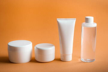 Various packages for body cream on orange background