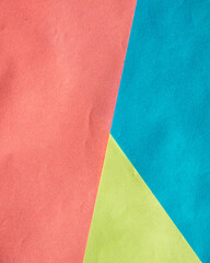Fototapeta premium Multi-colored background of several sheets of paper. the background is made of colored paper. Colorful sheets for backgrounds, designs and banners. Three-color geometric background-red, blue, yellow