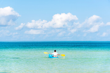 Fototapeta na wymiar Man paddling the kayak at beautiful sea beach tropical in summer