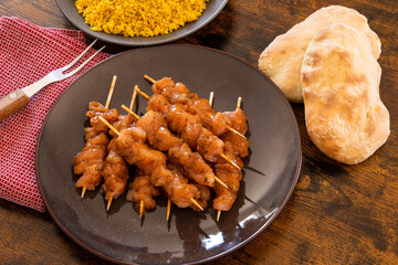 raw chicken skewer with tabbouleh in a dish on a table