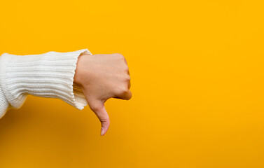 I don't like hands showing disapproving gestures thumb pointing down dissatisfied, reject, dislike Hand showing sign on yellow background in photo studio © FOTO SALE