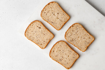Slices of a whole wheat bread on a marble tray. Four pieces. Healthy Hand Made Bread. Top view